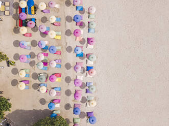 Indonesia, Bali, Nusa Dua, Aerial view of colorful umbrellas on resort beach - KNTF04051