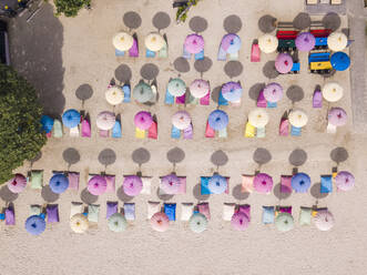 Indonesia, Bali, Nusa Dua, Aerial view of colorful umbrellas on resort beach - KNTF04053