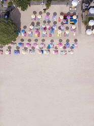 Indonesia, Bali, Nusa Dua, Aerial view of colorful umbrellas on resort beach - KNTF04058