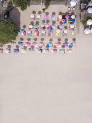 Indonesien, Bali, Nusa Dua, Luftaufnahme von bunten Sonnenschirmen am Strand des Resorts - KNTF04058