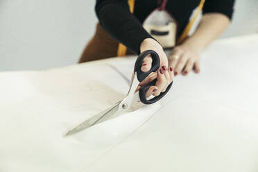 Hand of fashion designer cutting cloth - MTBF00262