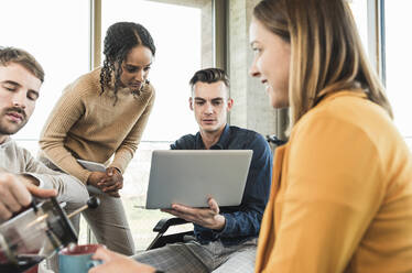 Young business people with laptop having a meeting in office - UUF19873