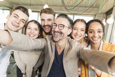 Gruppenbild von glücklichen Geschäftsleuten im Büro, lizenzfreies Stockfoto