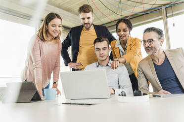 Business people having a meeting in office using laptop - UUF19914