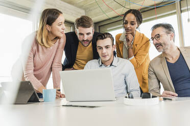 Business people having a meeting in office using laptop - UUF19915