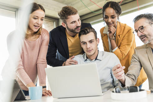 Business people having a meeting in office using laptop - UUF19916