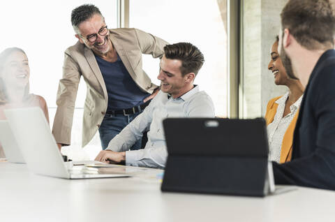 Glückliche Geschäftsleute bei einem Treffen im Büro, lizenzfreies Stockfoto