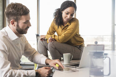 Businessman and businesswoman having a meeting in office - UUF19970