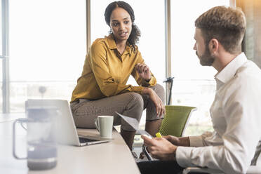 Businessman and businesswoman having a meeting in office - UUF19971