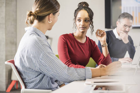 Zwei junge Geschäftsfrauen bei einem Treffen im Büro, lizenzfreies Stockfoto