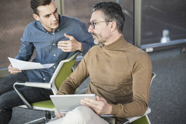 Reifer Geschäftsmann mit Tablet und junger Mann arbeitet im Büro - UUF20024