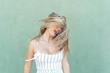 Blond young woman screaming and tossing her hair - AFVF04952
