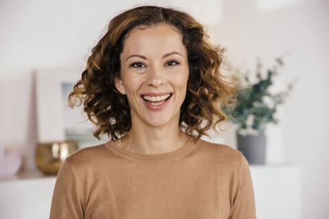 Portrait of happy brunette woman at home stock photo