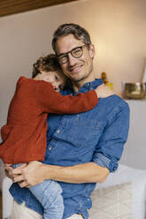 Porträt eines lächelnden Vaters mit Tochter zu Hause - MFF05011