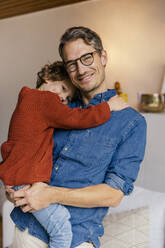 Portrait of smiling father carrying daughter at home - MFF05011