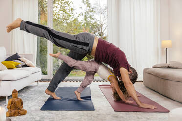 Father and daughter doing yoga together at home - MFF05015