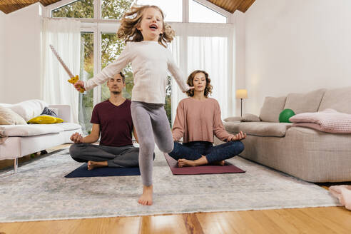 Exuberant girl with parents meditating at home - MFF05022