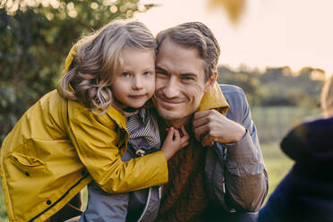 Portrait of girl hugging smiling father outdoors in autumn - MFF05031