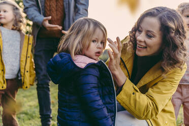 Glückliche Mutter mit Tochter und Familie im Freien im Herbst - MFF05032