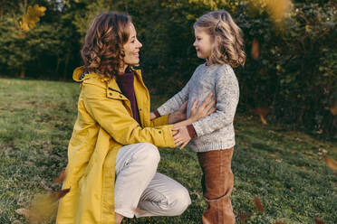 Lächelnde Mutter mit Tochter auf einer Wiese im Herbst - MFF05046