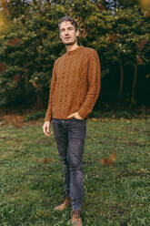 Portrait of a man standing on a meadow in autumn - MFF05049