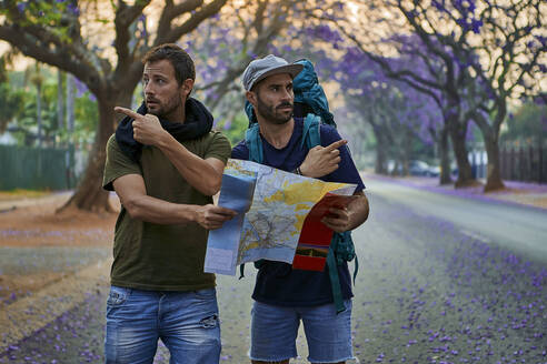 Backpackers with map on a street, Pretoria, South Africa - VEGF01263