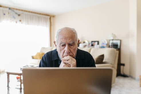 Porträt eines älteren Mannes, der zu Hause einen Laptop benutzt - JRFF03939