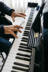 Crop view of senior man playing piano - JRFF03963