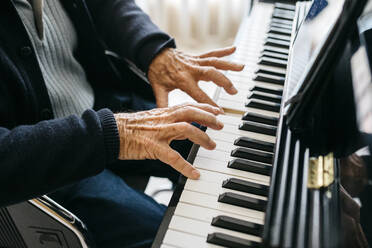 Crop view of senior man playing piano - JRFF03964