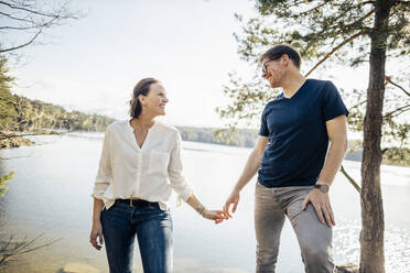 Glückliches Paar Hand in Hand am Seeufer, Forstsee, Kärnten, Österreich - DAWF01075