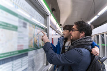 Vater und Tochter schauen in der U-Bahn-Station auf die Karte - ERRF02521