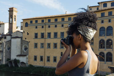 Junge Frau beim Fotografieren mit Kamera, Florenz, Italien - SODF00493