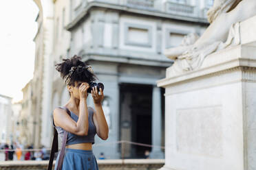 Young woman taking photo with camera, Florence, Italy - SODF00497