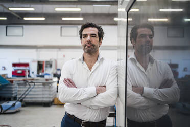 Portrait of a confident businessman in a factory - DIGF09040
