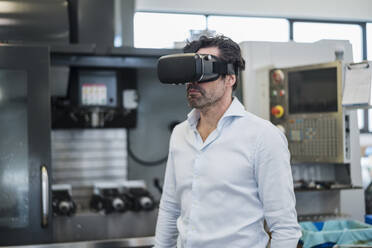 Geschäftsmann mit VR-Brille in einer Fabrik - DIGF09060