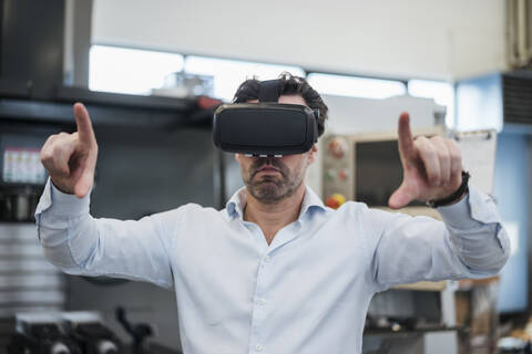 Businessman using VR glasses in a factory stock photo