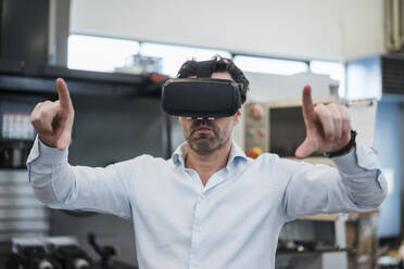 Businessman using VR glasses in a factory - DIGF09062