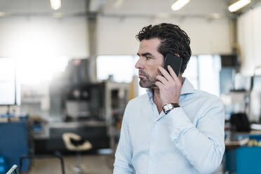 Geschäftsmann am Telefon in einer Fabrik - DIGF09077