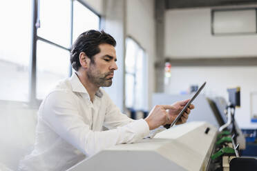 Businessman using tablet in a factory - DIGF09103