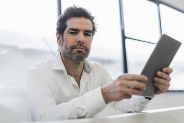 Portrait of a businessman holding tablet in a factory - DIGF09104