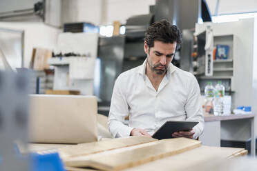 Businessman using tablet in a factory - DIGF09106