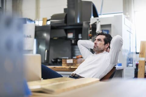 Geschäftsmann in einer Fabrik, der eine Pause macht, lizenzfreies Stockfoto