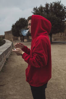 Blonder junger Mann raucht eine Zigarette in Lleida - ACPF00650