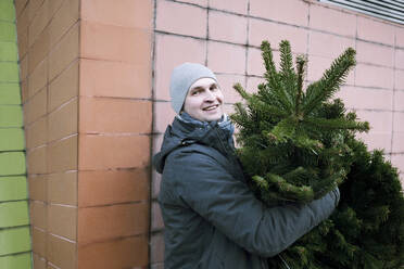 Lächelnder Mann mit Tannenbaum - EYAF00792