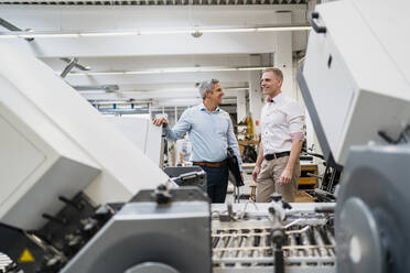 Zwei lächelnde Kollegen in einer Fabrik - DIGF09147