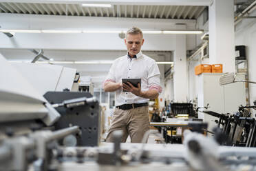 Businessman using a tablet in a factory - DIGF09149