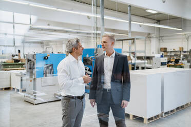 Two businessmen talking in a factory - DIGF09165