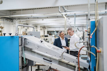 Two businessmen with tablet talking in a factory - DIGF09170