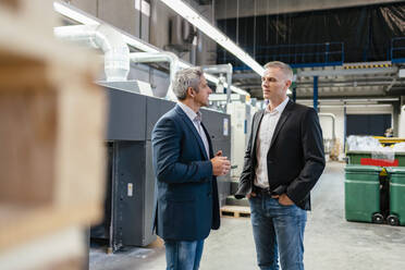 Two businessmen talking in a factory - DIGF09214