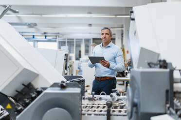 Businessman using a tablet in a factory - DIGF09235